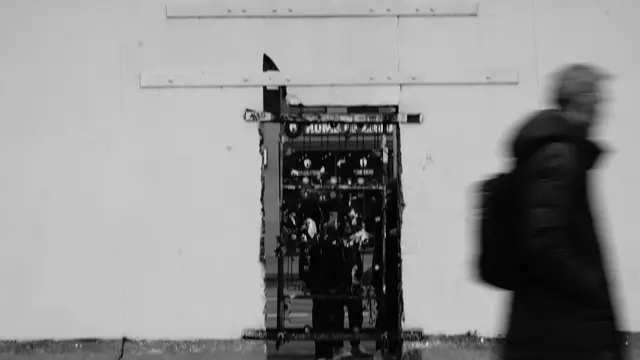 Blurred passerby in front of a covered doorway