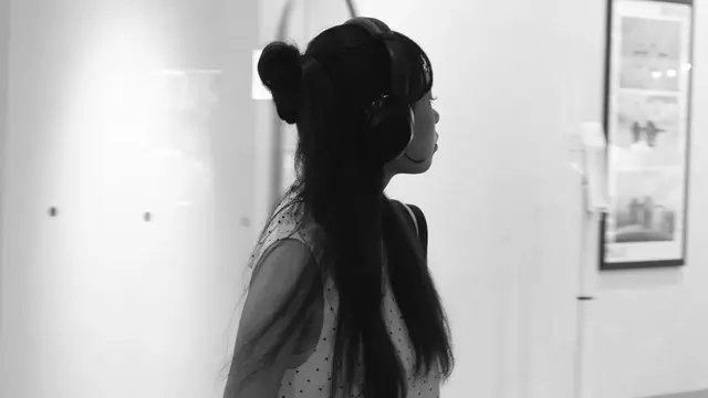 Girl in headphones, lost in the exhibition