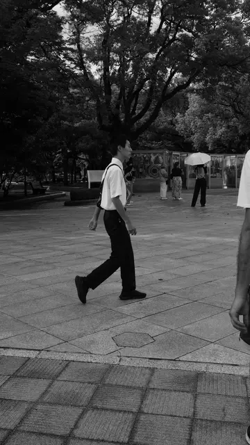 Student walking past the paper-crane cases, Peace Memorial Park