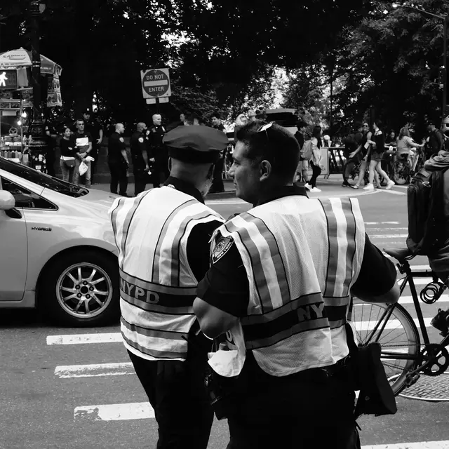 Two NYPD officers in hi-vis vests at a crossing