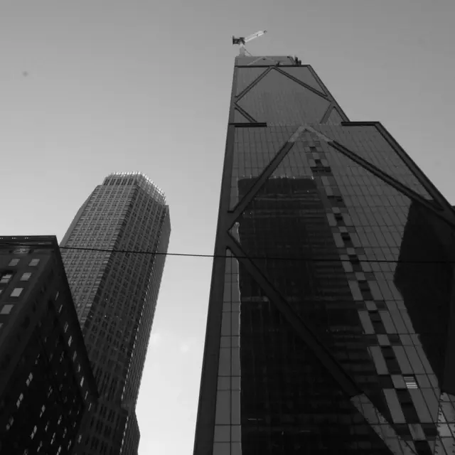 Glass towers from below with a crane on top