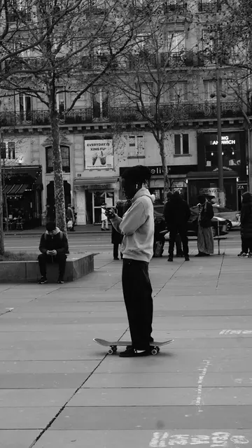 Skater checking his phone, standing on the board