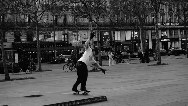Skater carving past Café République, arm raised
