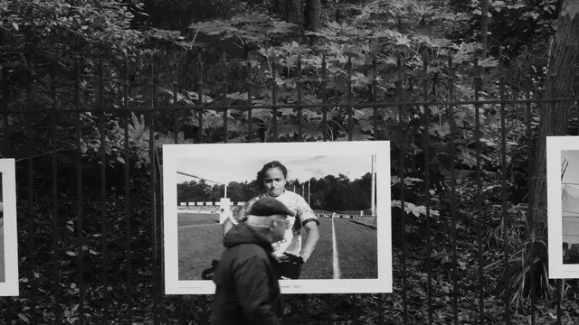 Passerby in front of an open-air photo exhibition on the railings