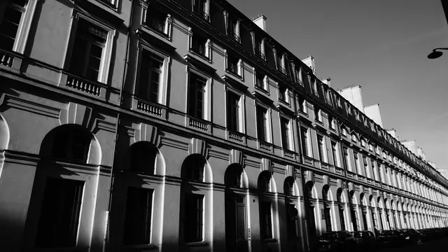 Raking light across a long Haussmann arcade façade