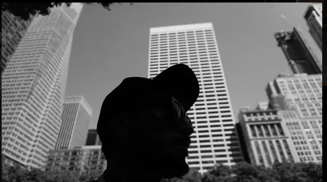 Silhouette with cap against skyscrapers