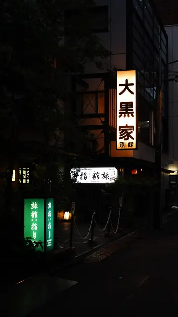 Ryokan signs glowing in an Asakusa backstreet at night