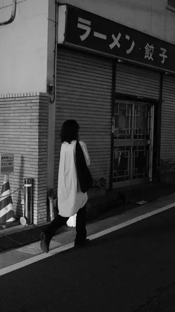 Passerby in front of a shuttered ramen-gyoza joint