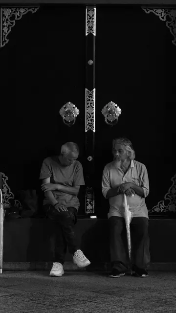 Two elders resting against the great temple door