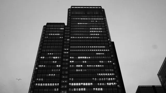 Office tower at dusk, scattered windows still lit