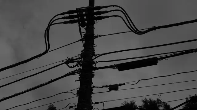 Tangle of power lines against a grey sky